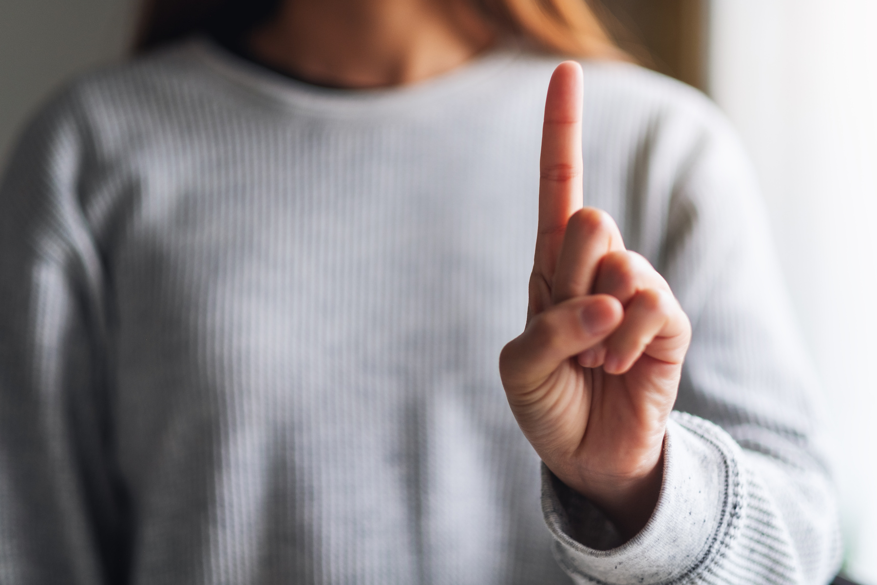 Closeup Image of a Woman Making and Showing Number One Hand Sign